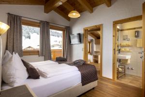 a bedroom with a large bed and a bathroom at Gamsalm in Kals am Großglockner