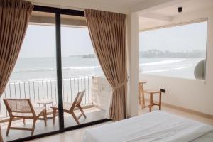 a bedroom with a balcony with a view of the ocean at Meli Beach in Galle +25 photos