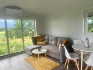 a living room with a couch and a table at Cozy accommodation on horse farm in Alunda