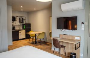 a room with a kitchen and a table and chairs at Tulip Inn Honfleur Residence & Spa in Honfleur