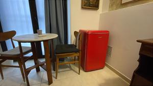 a red refrigerator in a room with a small table at Guiscardo Suites in Bari