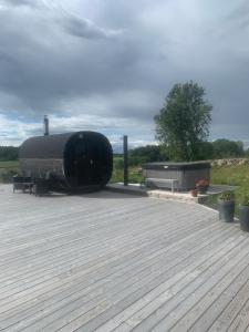 a large black building sitting on top of a deck at Cozy accommodation on horse farm in Alunda +4 photos