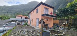 ein rosa Haus mit einem Garten davor in der Unterkunft Oceanview room in Ponta Delgada