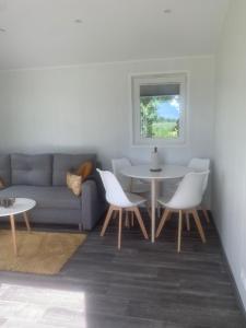 a living room with a couch and a table and chairs at Cozy accommodation on horse farm in Alunda