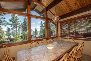 a dining room with a table and chairs and windows at Coates By Hauserman Rentals in Tahoe City