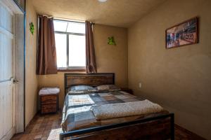 a bedroom with a bed and a large window at Cuanax hotel boutique tematico - Mineral de Pozos in Mineral de Pozos
