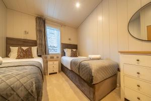 a small bedroom with two beds and a window at Park Lodge in Penrith