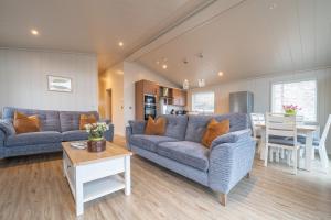 a living room with two blue couches and a table at Park Lodge in Penrith