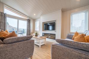 a living room with two couches and a tv at Park Lodge in Penrith