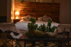 a room with a bed and a table with pineapples on it at Peryn Suites Kinubi, Hoima City, Uganda in Hoima