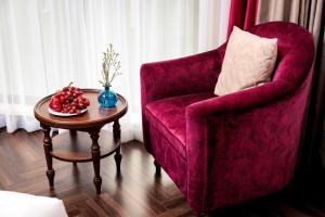 a living room with a red chair and a table at Eli Rina Hotel in Hanoi