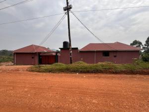 a red building with a pole in front of it at Peryn Suites Kinubi, Hoima City, Uganda in Hoima