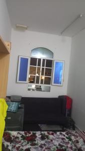 a room with a bed and a window and a couch at BRAZIL House in Muscat