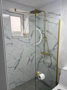 a bathroom with a shower with white marble at 7 min walking to airport in Otopeni