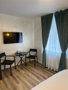a room with a table and two chairs and a tv at 7 min walking to airport in Otopeni