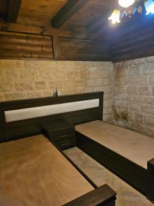 two beds in a room with wooden walls at בית האומן in Safed