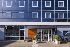 a blue building with a bench in front of it at Holiday Inn Express Antwerpen City North by IHG in Antwerp