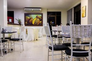a dining room with tables and chairs with bananas on the wall at Hotel arimaca in Ríohacha