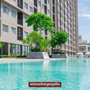 a swimming pool in front of a tall building at Modera Suites at Parkland Condo TK in Phnom Penh