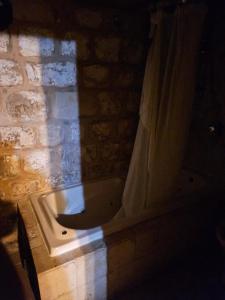 a bathroom with a bath tub in a brick wall at בית האומן in Safed +1 photo