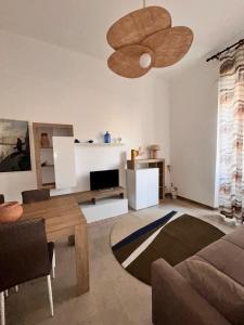 a living room with a couch and a ceiling fan at Odissea Apartment City Center & 2 Min to Beach in Nettuno