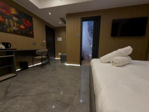 a hotel room with a bed and a desk and a television at Il Tempio Luxury Rooms in Cosenza +54 photos