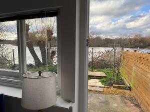 a lamp in front of a window with a view at Lakeside Haven in The Hyde
