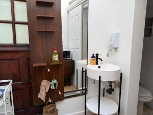 a bathroom with a sink and a toilet and a mirror at Lakeside Haven in The Hyde +11 photos