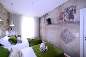 two beds in a room with green and white at VILA DE PONTE GUEST HOUSE in Ponte de Lima