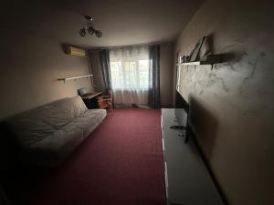 a bedroom with a bed and a table and a window at Coso in Filiaşi