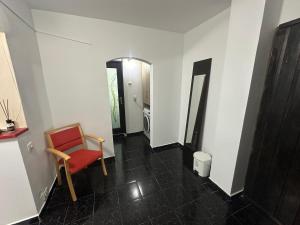 a hallway with a red chair in a room at Coso in Filiaşi