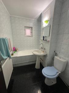 a bathroom with a tub and a toilet and a sink at Coso in Filiaşi