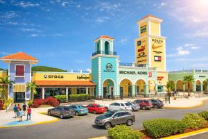 a shopping center with cars parked in a parking lot at Blue Lodge in Manati