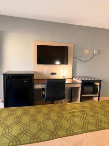 a hotel room with a bed and a desk with a computer at Milan inn & Suites in Milan