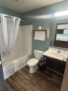 a bathroom with a toilet and a tub and a sink at WoodSpring Suites Nashville Airport in Nashville +16 photos
