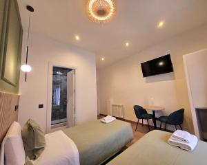 a room with two beds and a table and a tv at Hostal Main Street Madrid in Madrid