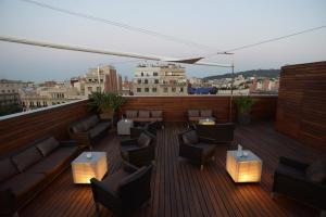 a rooftop patio with couches and tables on a building at Hotel Soho in Barcelona