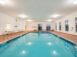 a swimming pool with blue water in a building at Pellston Lodge in Pellston