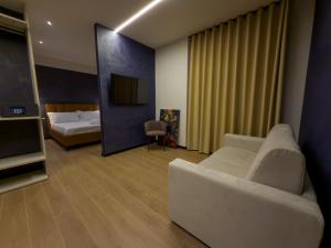 a living room with a couch and a bed at Il Tempio Luxury Rooms in Cosenza