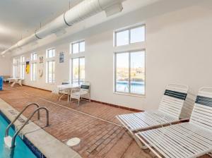 a pool room with two chairs and a table at Pellston Lodge in Pellston