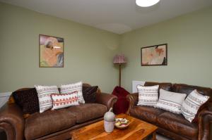 a living room with two couches and a coffee table at Dunmore Coastal Retreat in Dunoon