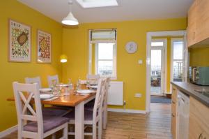 a kitchen and dining room with a table and chairs at Dunmore Coastal Retreat in Dunoon