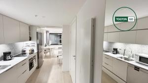 a kitchen with white cabinets and white appliances at Nice Växjö City Stay In Arenastaden Vida Arena in Växjö