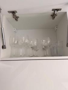 a row of wine glasses sitting on a shelf at Loft Apartment with Parking in Poruba +27 photos