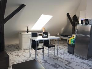 a kitchen with a table with two chairs and a refrigerator at Loft Apartment with Parking in Poruba