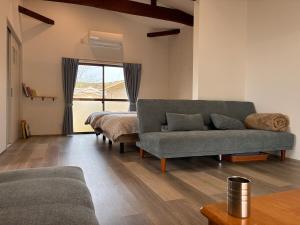 a living room with a couch and a bed at 細島 Base Clutch in Hyuga +26 photos
