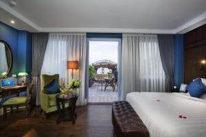 um quarto de hotel com uma cama, uma mesa e cadeiras em O'Gallery Premier Hotel & Spa em Hanói