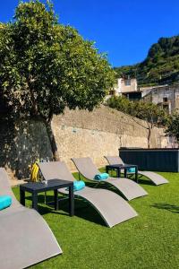 a row of tables and chairs on the grass at Eden Holiday in Minori