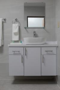 a white bathroom with a sink and a mirror at Blue Lodge in Manati +22 photos