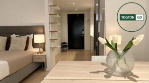 a bedroom with a bed and a vase with flowers in it at Nice Växjö City Stay In Arenastaden Vida Arena in Växjö +18 photos